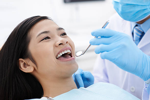 Close-up image of dentist using mouth mirror during check-up